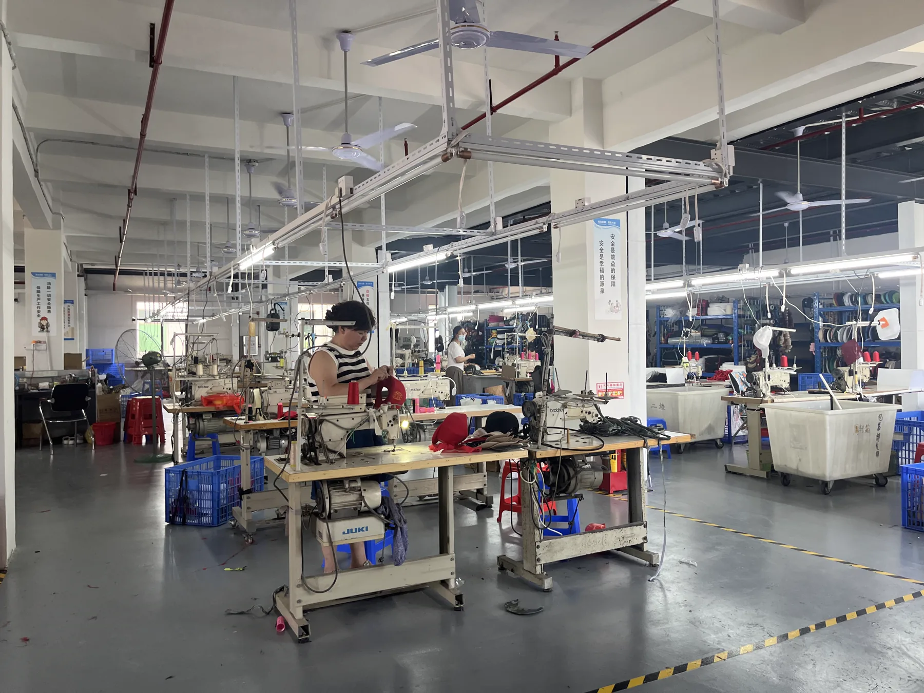 SXMX hat sewing workshop in Dongguan, China with staff working at industrial machines